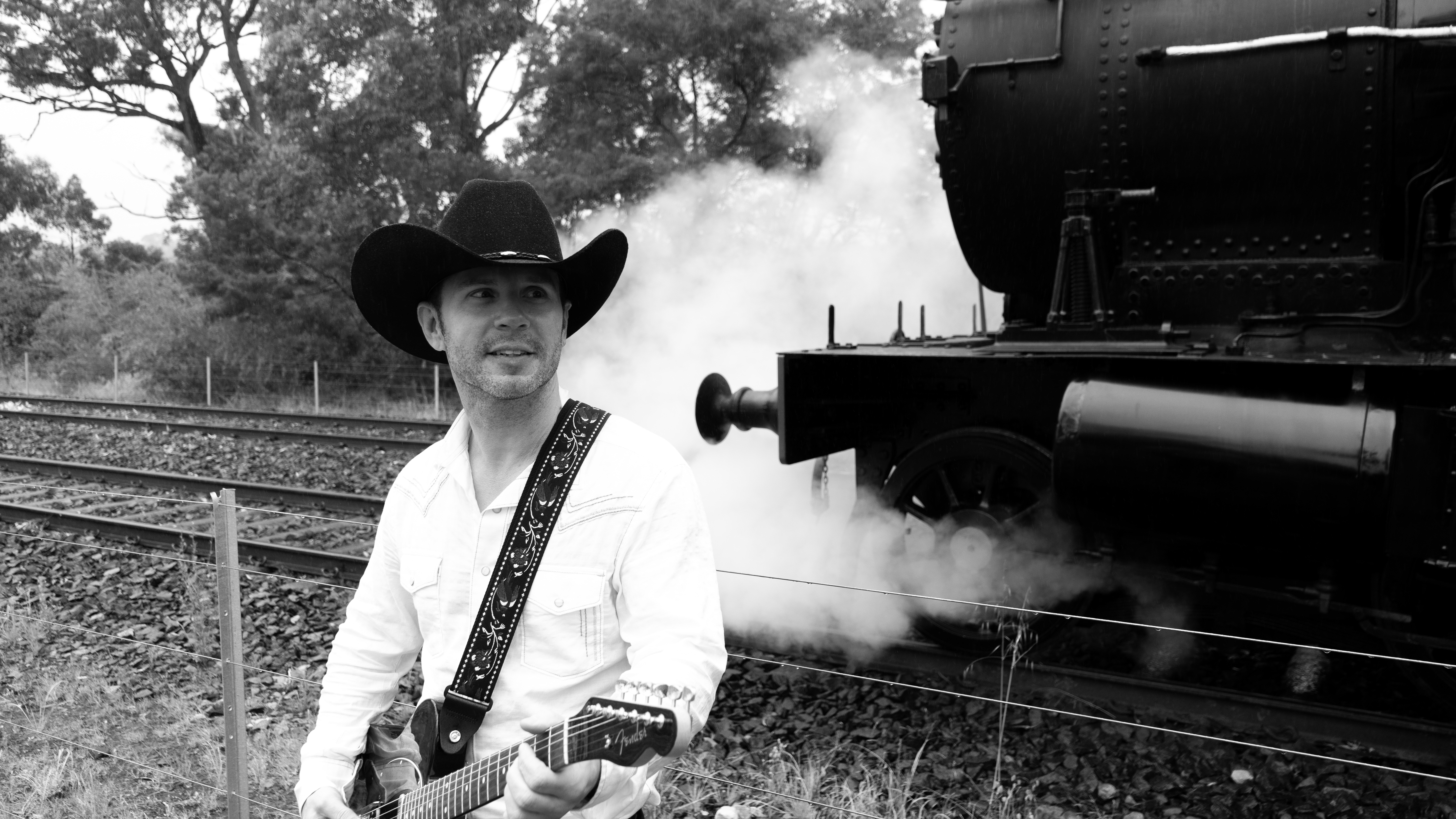 Kincade Stevens with guitar at steam locomotive
